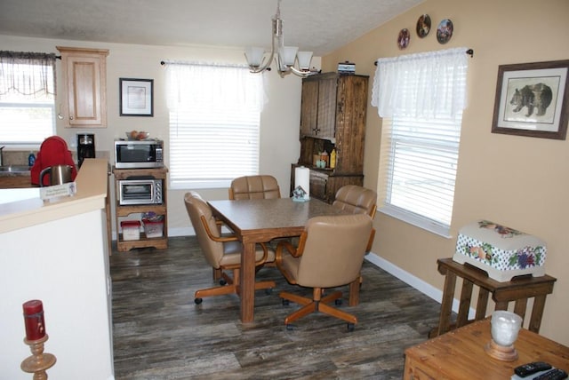 dining room featuring a wealth of natural light, lofted ceiling, a notable chandelier, and dark wood-style floors