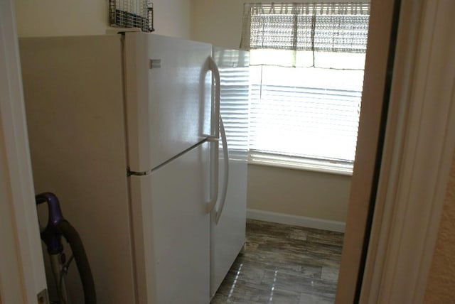 kitchen featuring baseboards and freestanding refrigerator