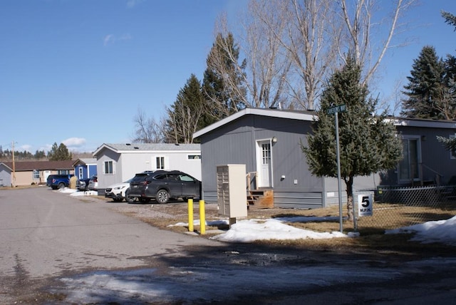 view of front facade featuring a residential view, fence, and entry steps