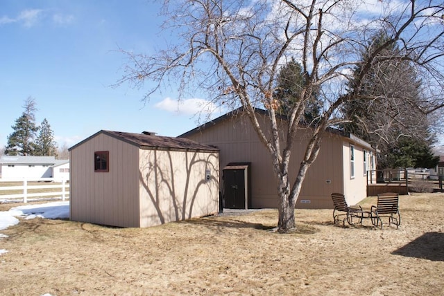 exterior space with crawl space, a shed, an outdoor structure, and fence