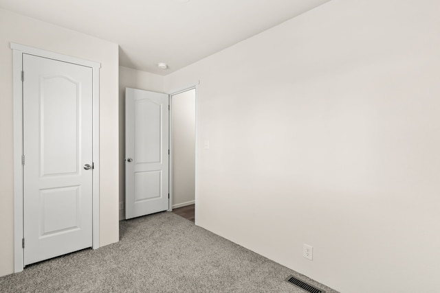 unfurnished bedroom featuring visible vents and carpet