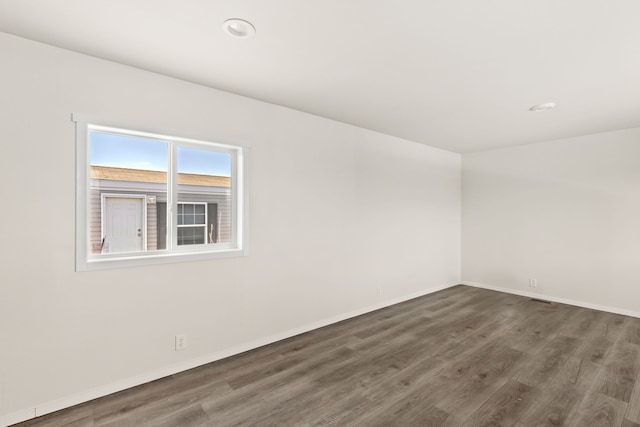 unfurnished room with baseboards and wood finished floors