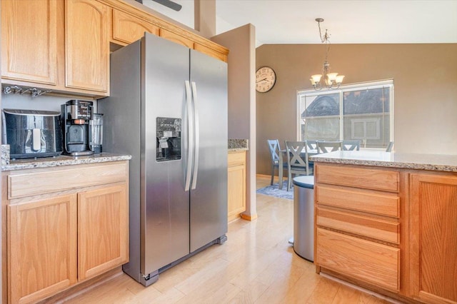 kitchen featuring stainless steel fridge with ice dispenser, light brown cabinetry, vaulted ceiling, light wood-style floors, and an inviting chandelier