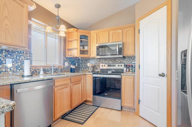 kitchen featuring light wood-style flooring, light brown cabinets, a sink, stainless steel appliances, and vaulted ceiling