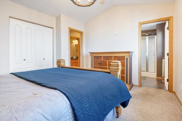 bedroom with baseboards, a closet, carpet floors, and lofted ceiling