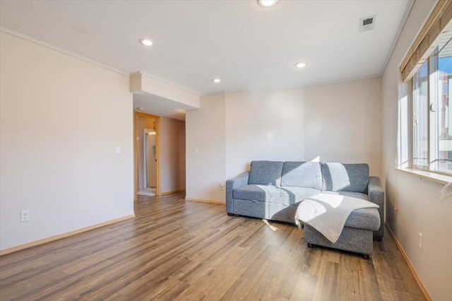 sitting room featuring recessed lighting, ornamental molding, baseboards, and wood finished floors