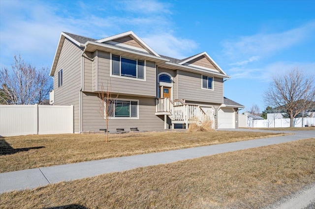 bi-level home featuring a front lawn and fence