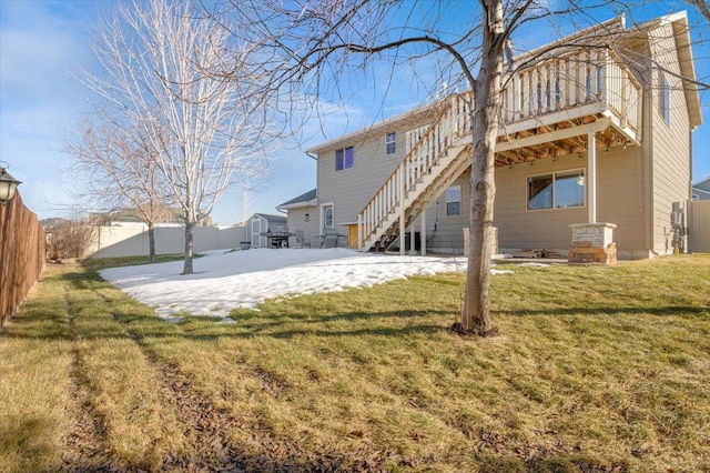 back of house with stairs, a yard, and fence