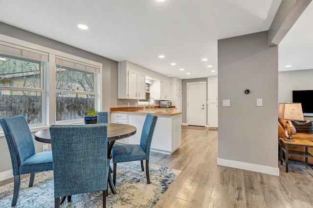 dining room featuring recessed lighting, light wood-style flooring, and baseboards