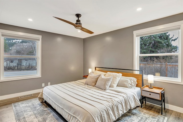 bedroom featuring wood finished floors, baseboards, visible vents, recessed lighting, and ceiling fan