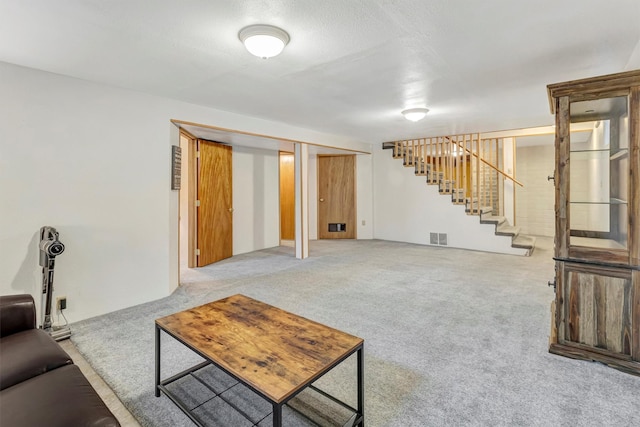 living room featuring stairway, visible vents, and carpet floors