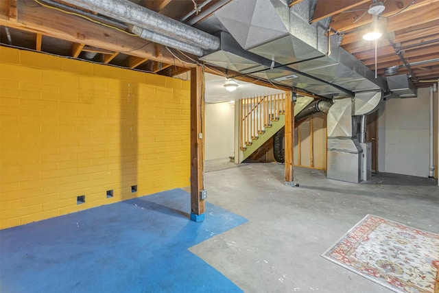 unfinished basement with stairway and heating unit