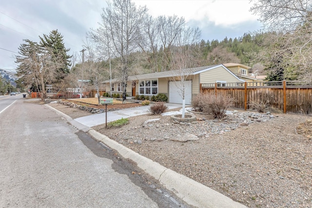 ranch-style home featuring an attached garage and fence