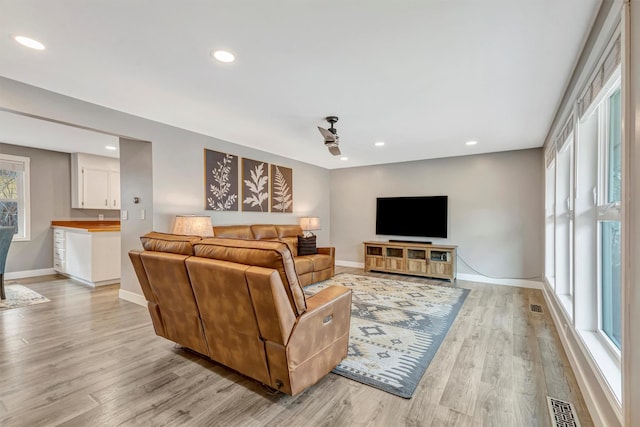 living area with recessed lighting, baseboards, visible vents, and light wood finished floors