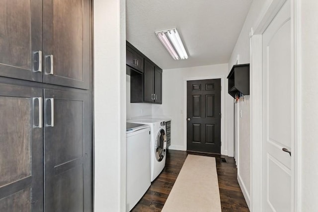 laundry room featuring dark wood-type flooring, independent washer and dryer, a textured ceiling, cabinet space, and baseboards