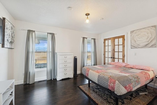 bedroom featuring dark wood finished floors, multiple windows, french doors, and baseboards