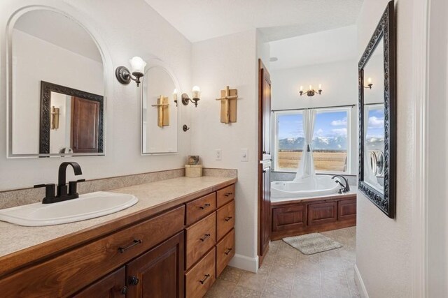 full bathroom featuring a bath, vanity, and baseboards