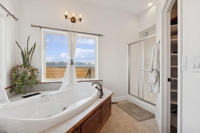 bathroom with a walk in closet, baseboards, a stall shower, and a whirlpool tub