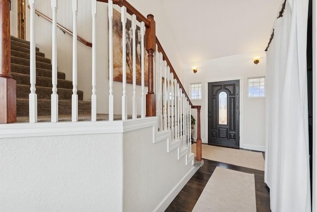 entryway featuring dark wood finished floors, stairway, and baseboards