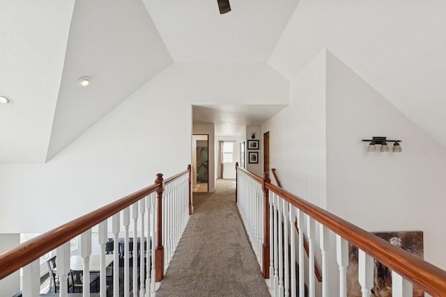 hallway featuring an upstairs landing, lofted ceiling, and carpet