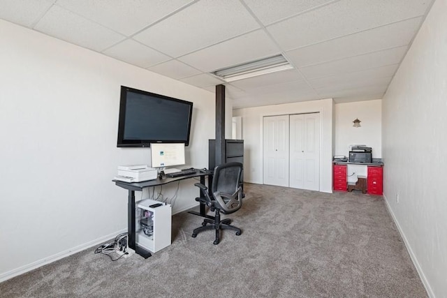 carpeted office featuring a drop ceiling and baseboards