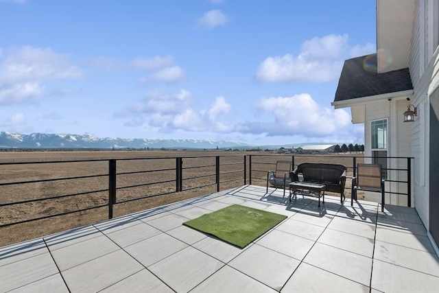 view of patio with a balcony and a mountain view