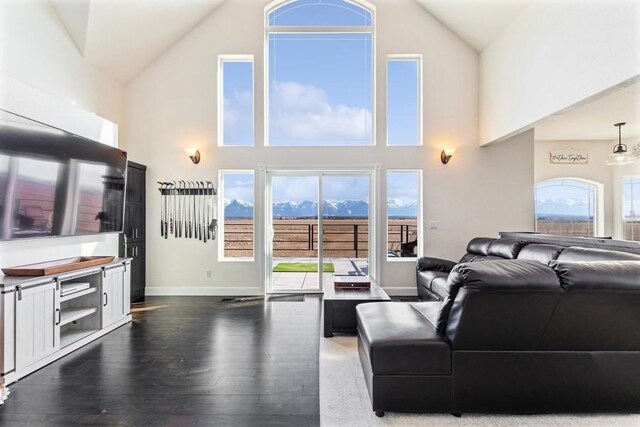 living room with baseboards, high vaulted ceiling, a healthy amount of sunlight, and dark wood-style floors