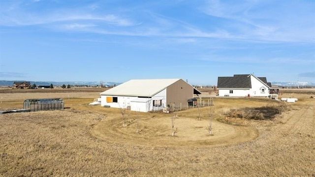 view of property exterior featuring an outdoor structure and a rural view