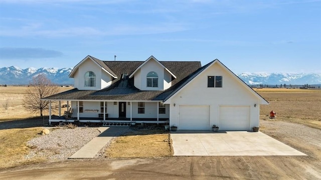 view of front of property with a mountain view, a porch, concrete driveway, and an attached garage