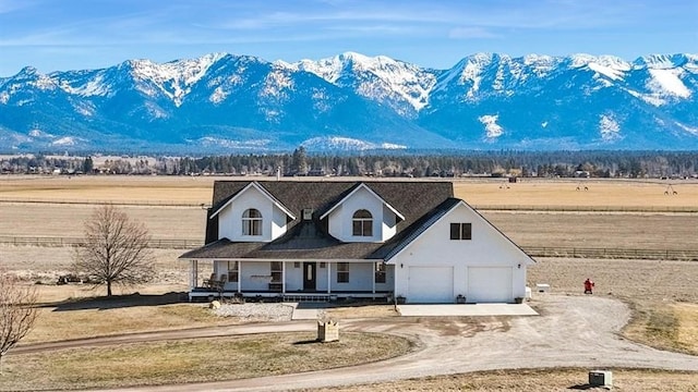 view of front of property featuring covered porch, a mountain view, driveway, and a garage