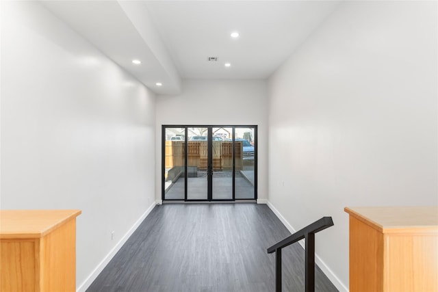 empty room featuring dark wood-style floors, recessed lighting, baseboards, and visible vents