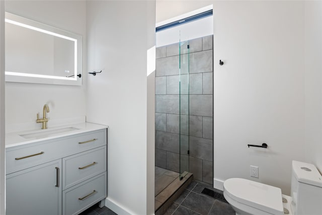 bathroom featuring tile patterned flooring, baseboards, toilet, tiled shower, and vanity