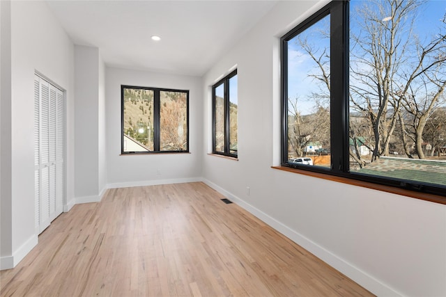 unfurnished bedroom featuring light wood-style flooring, recessed lighting, baseboards, and visible vents