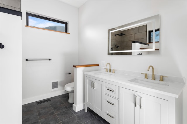 bathroom with toilet, baseboards, visible vents, and a sink