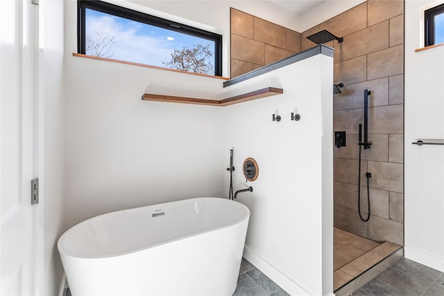 full bath featuring a freestanding tub, a walk in shower, and baseboards