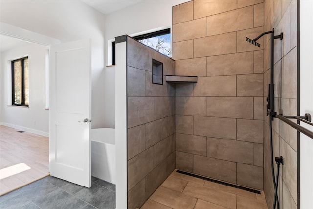 bathroom featuring a tile shower and a freestanding bath