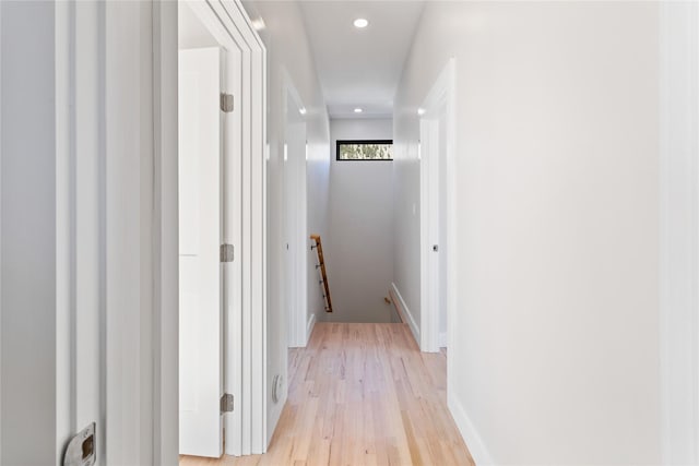 hallway featuring recessed lighting, an upstairs landing, baseboards, and light wood finished floors