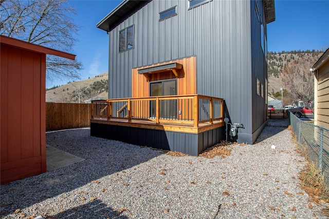 back of property with a deck and a fenced backyard