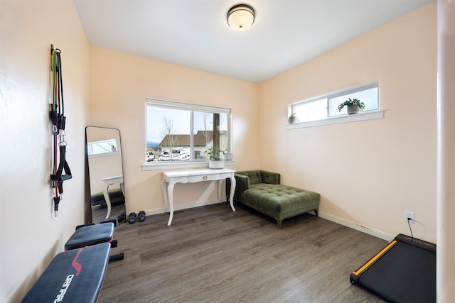 exercise area with wood finished floors and baseboards