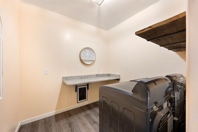 laundry area featuring baseboards, dark wood-type flooring, and laundry area