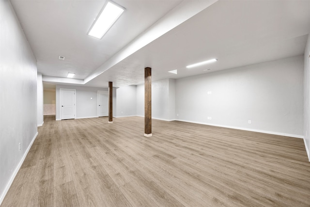 finished below grade area with baseboards and light wood-style flooring