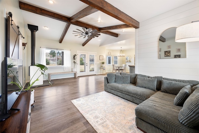 living area with lofted ceiling with beams, wood finished floors, french doors, wood walls, and a wood stove