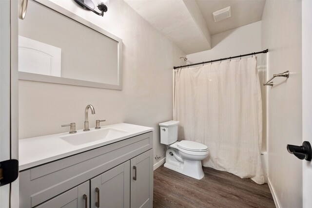 bathroom with visible vents, toilet, wood finished floors, baseboards, and vanity