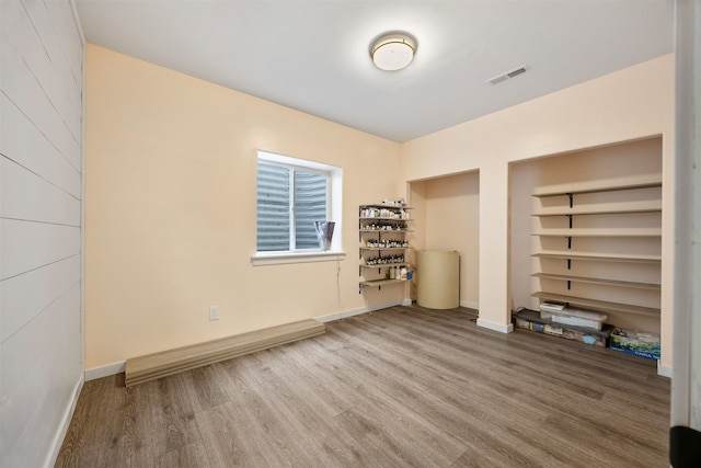 spare room with visible vents, baseboards, and wood finished floors