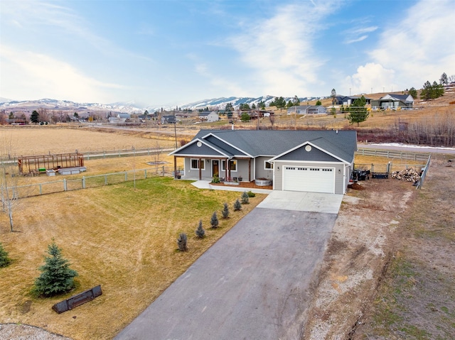 ranch-style house featuring fence, a porch, a front yard, a garage, and driveway