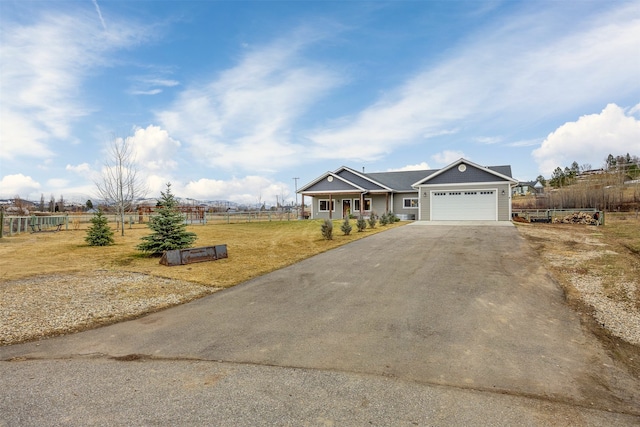 view of front of property featuring aphalt driveway, an attached garage, a front yard, and fence