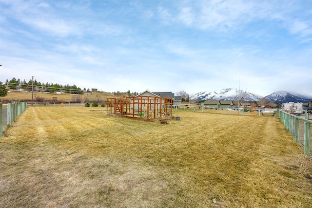 view of yard with a rural view, a garden, and fence