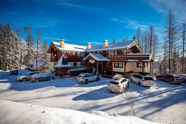 chalet / cabin featuring uncovered parking and a chimney