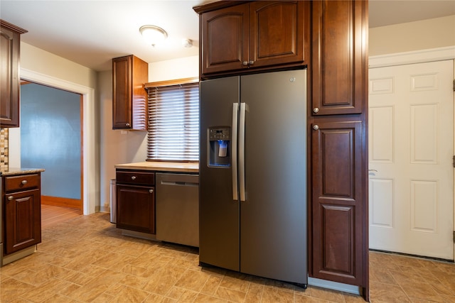 kitchen with light countertops, baseboards, and appliances with stainless steel finishes