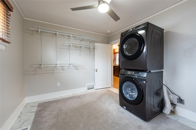 clothes washing area featuring visible vents, marble finish floor, stacked washer and clothes dryer, baseboards, and laundry area